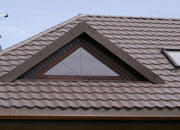 Blachodachówka na dachu domku jednorodzinnego z daleka bardzo przypomina zwykłą dachówkę ceramiczną.
