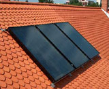 Kolektory słoneczne płaskie zainstalowane na dachu domu jednorodzinnego. Oprócz swej podstawowej funkcji ekologicznej, stanowią również ciekawy dodatek wizualny.
